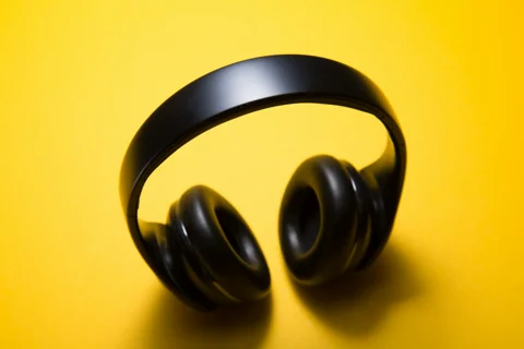 Wireless headphones on a warm yellow background